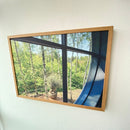 Akustikbillede med skovudsigt og krukkeplante. Træramme med moderne design.
