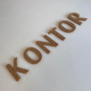 Bogstaverne "KONTOR" på flade overflade, ser ud som kork.