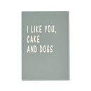Grønt kort med teksten "I LIKE YOU, CAKE AND DOGS" i hvide bogstaver.