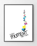 Farverige fugle flyver opad fra teksten "Every Moment Matters" på en hvid baggrund.