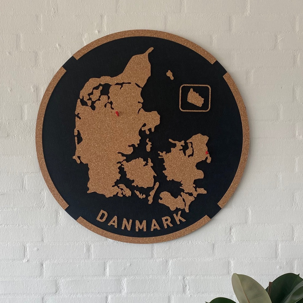 Rundt vægpanel med Danmarkskort udskåret i kork på mørk baggrund; 