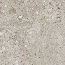 Overflade med beige terrazzo mønster og spredte farvede fragmenter i varierende størrelser.