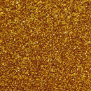 Skinnende overflade med guldfarvet glitter, der reflekterer lys og skaber en glitrende effekt.