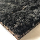 Kvadratisk panel med sort mos, tekstureret overflade og lagdelt design på brændt kork.