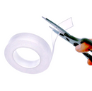 En transparent nano gel tape i en rulle bliver klippet med en saks.